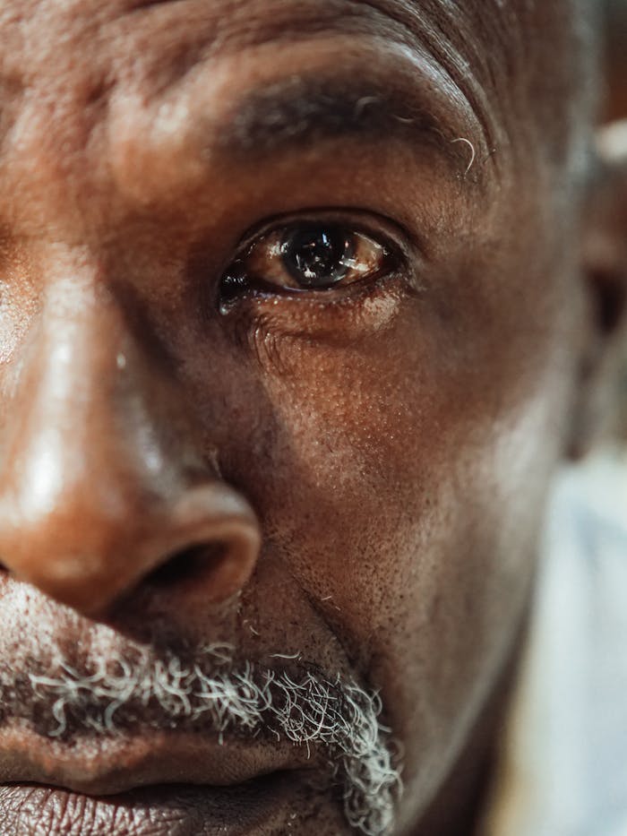 about-06 A close-up of an elderly man's face showing deep emotion and reflection.